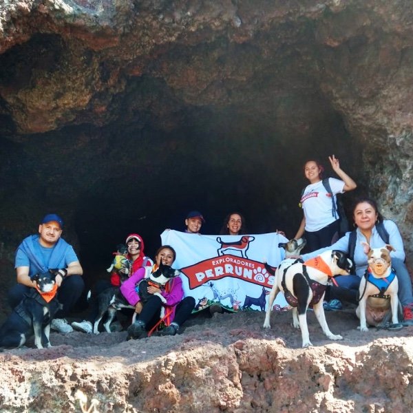 Equipo de senderistas de Exploradores Perrunos en una gruta posando con su lona