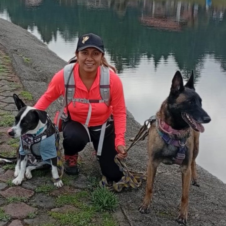 Mujer posando en un lago con sus dos perros